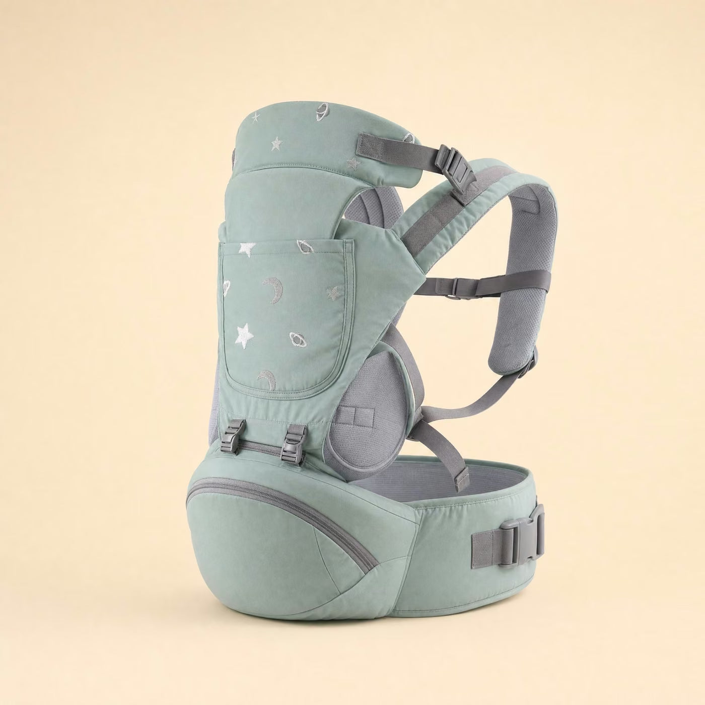 Le Porte-Câlin Ploumi, porte-bébé vert sauge avec assise ventrale et motif lunes et étoiles brodé