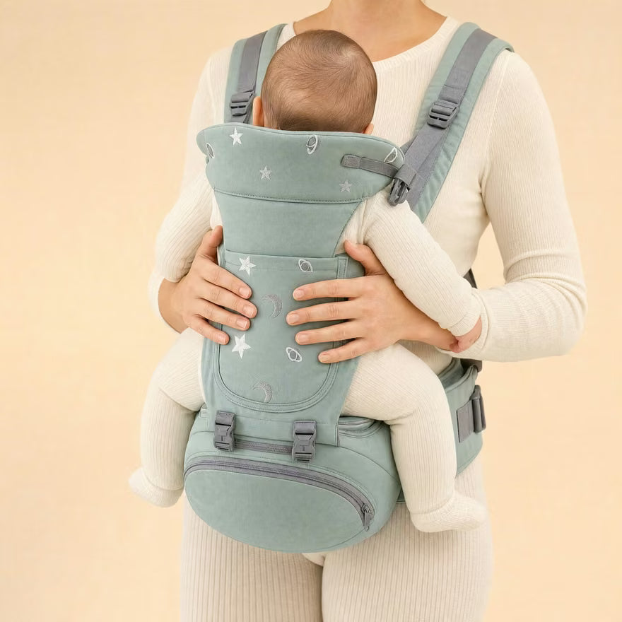 Bébé assis sur l'assise ventrale du Porte-Câlin, maintenu par les bras du parent