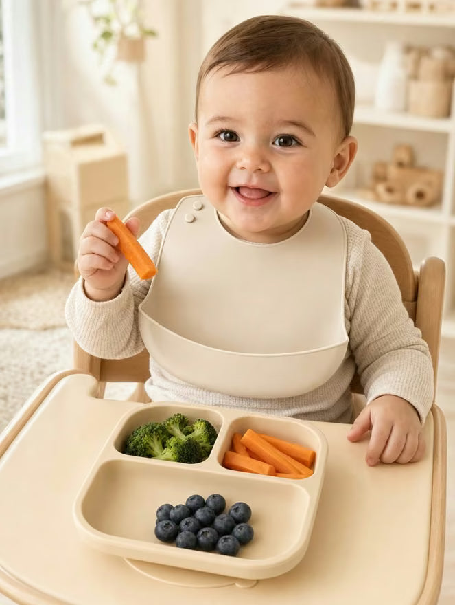 Bébé attablé avec le bavoir et l’assiette Ploumi