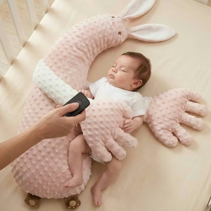 Une main règle la vitesse à la télécommande, près de bébé endormi